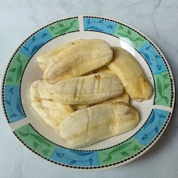 Kupas pisang dan geprek ringan hingga sedikit pipih.