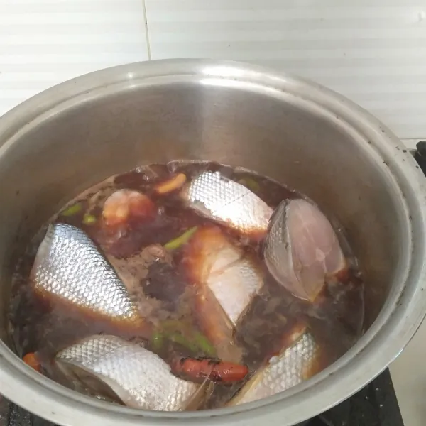 Masukkan ikan dan masak hingga ikan setengah matang.