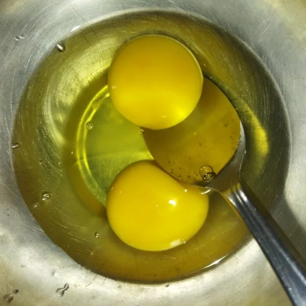 Siapkan wadah, masukkan 2 butir telur, lalu kocok lepas, sisihkan.
