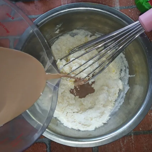 Larutkan susu kental manis dalam air, kemudian tuang ke dalam tepung sedikit demi sedikit hingga tepung tidak bergerindil.
