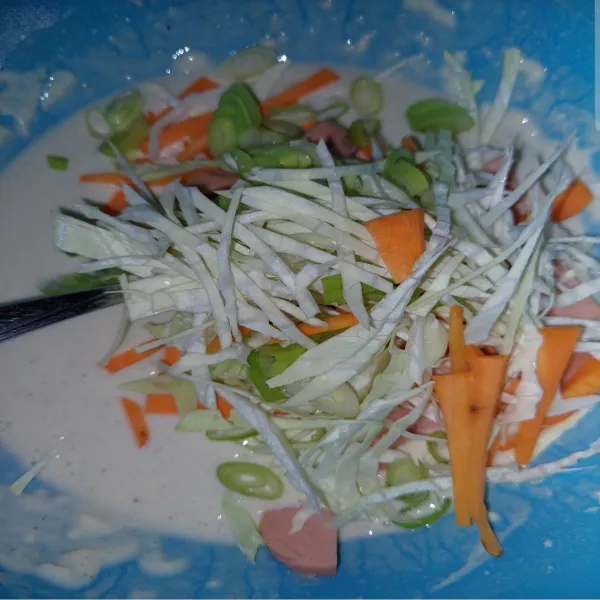 Masukkan irisan sosis, kol, wortel, dan daun bawang. Aduk sampai rata.