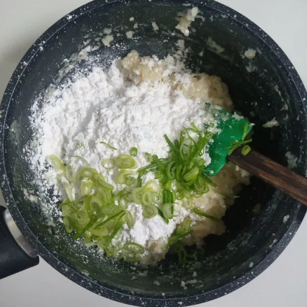 Masukkan tepung tapioka dan daun bawang, uleni sampai tercampur rata.