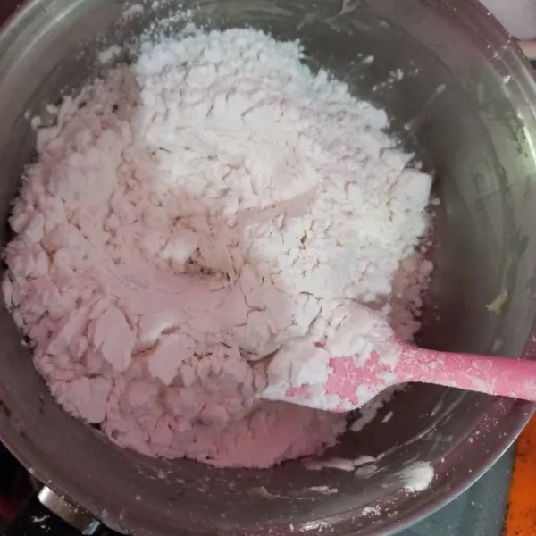 Setelah adonan terigu hangat, tuang tepung tapioka, uleni hingga tercampur rata dan adonan bisa dipulung.