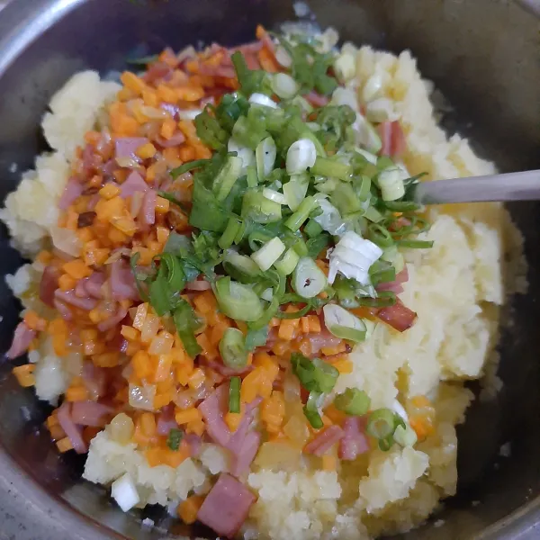Campurkan kentang tumbu dengan tumisan wortel, daun bawang, parutan keju, garam dan lada. Aduk rata.