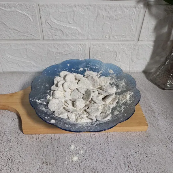 Baluri irisan bakso dengan campuran tepung hingga merata.