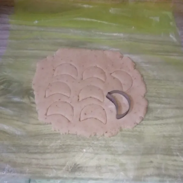 Taruh adonan di atas plastik atau kertas roti, kemudian pipihkan dengan bantuan rolling pin, kemudian bentuk menggunakan cookies cutter.