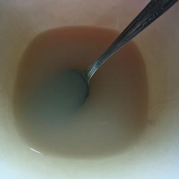 Siapkan wadah, masukkan ragi dan gula pasir, lalu tambahkan air hangat, tunggu hingga berbusa.