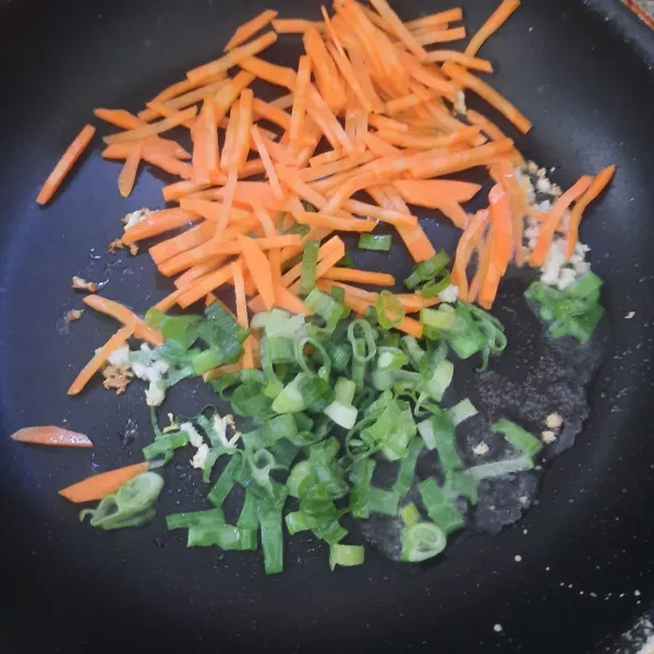 Panaskan minyak,tumis bawang putih sampai harum. Masukkan wortel dan bawang daun, masak sampai setengah matang.