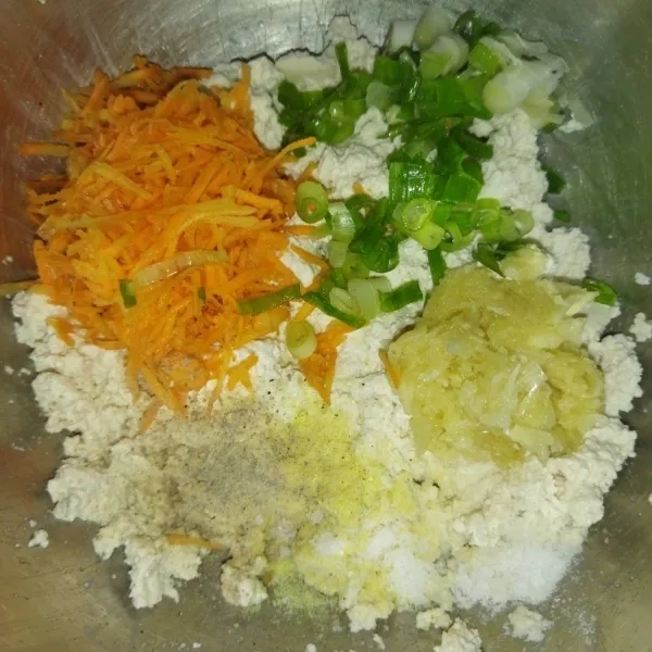 Tambahkan wortel, daun bawang, bawang putih halus, garam, kaldu bubuk dan lada bubuk, aduk rata, lalu cicipi.