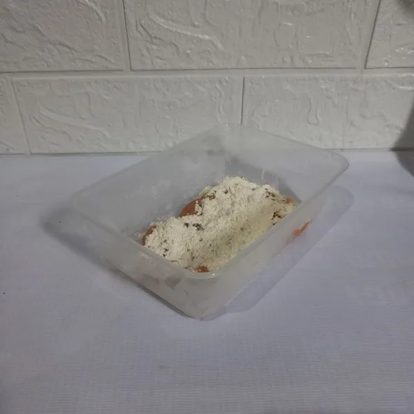 Ambil 2 sdm tepung pelapis. 
Tuang di atas ayam dan tambahkan air. 
Aduk sampai rata.