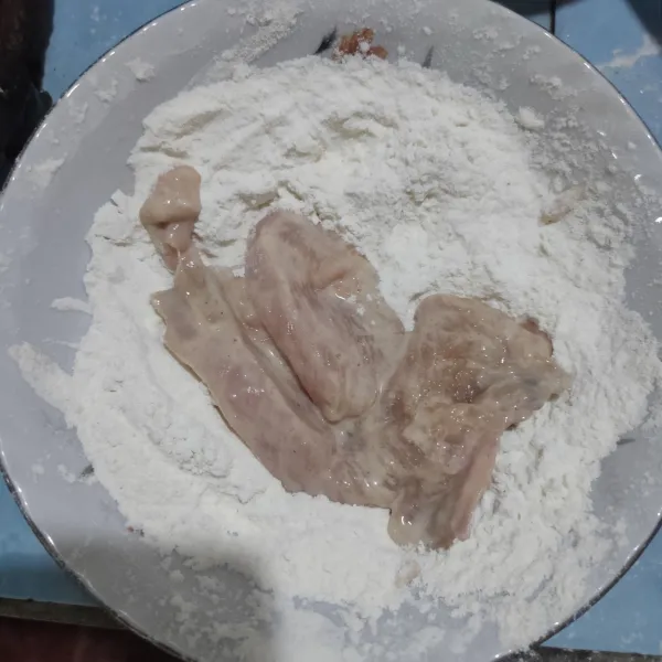 Siapkan mangkuk, masukkan tepung bumbu, ambil 1 potong ayam lalu balur ke dalam tepung, cubit perlahan ayam agar terbentuk serat.