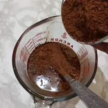 Tuangkan bubuk coklat ke dalam air panas dan aduk hingga larut.