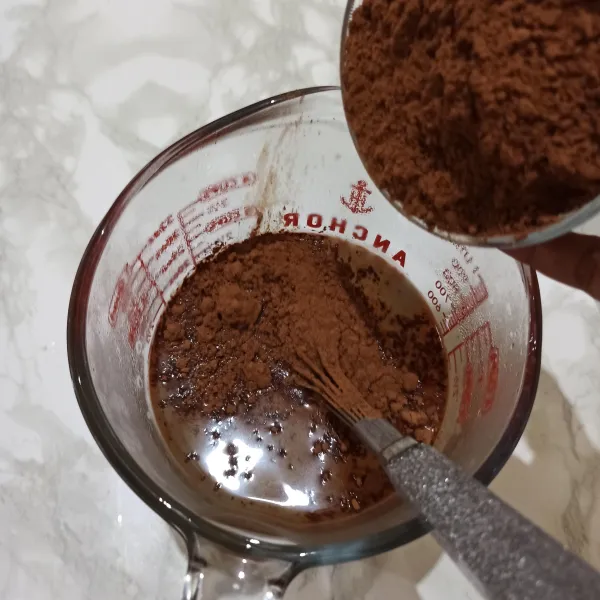 Tuangkan bubuk coklat ke dalam air panas dan aduk hingga larut.