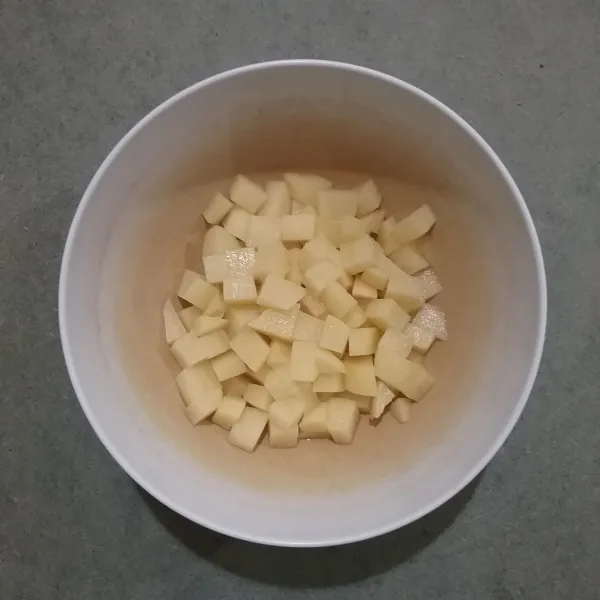 Kupas kentang, cuci bersih, potong dadu, rendam dalam air garam sekitar 10 menit, angkat dan tiriskan.