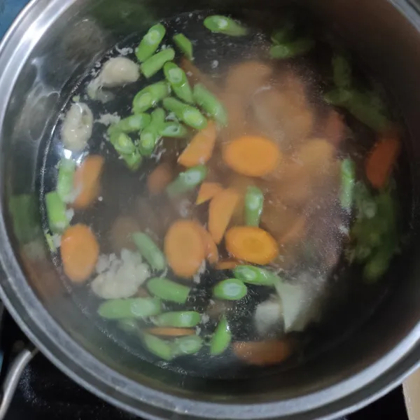 Rebus secukupnya air hingga mendidih lalu masukkan buncis dan wortel.