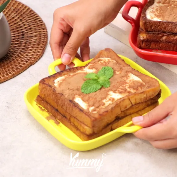 Tekan-tekan permukaan atas roti menggunakan sendok, kemudian tuangkan whipped cream. Lalu taburkan bubuk minuman coklat di atasnya. Choco Lava Toast siap untuk disajikan.