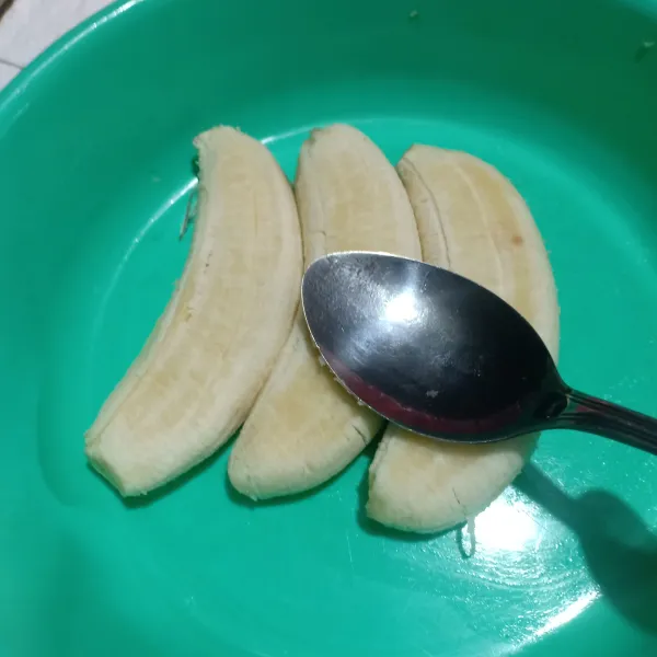 Pipihkan pisang pakai sendok.