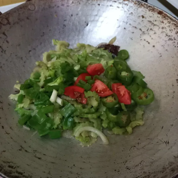Masukan irisan bawang daun dan tomat masak hingga matang