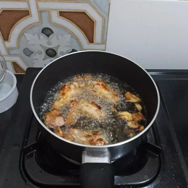 Panaskan minyak goreng, kemudian goreng ayam dan bawang putih geprek dengan api sedang cenderung kecil hingga matang kecokelatan, angkat dan tiriskan.