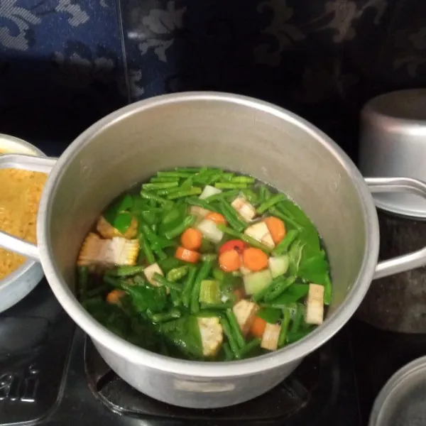 Setelah daging empuk masukkan bumbu halus kemudian sayuran, masak hingga air mendidih kembali dan  sayuran layu.