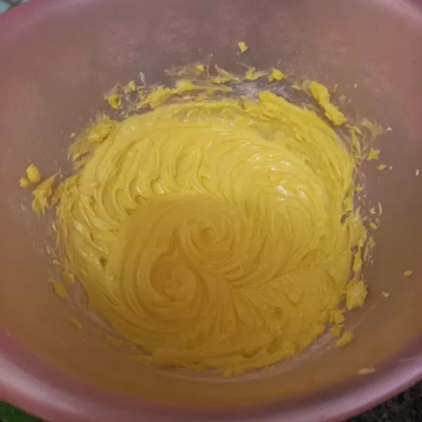 Mixer sebentar margarin, butter dan kuning telur hingga rata