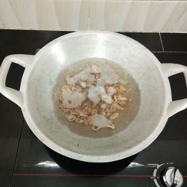 Potong-potong cumi asin, lalu rebus dalam air mendidih selama 15 menit. Angkat dan tiriskan.