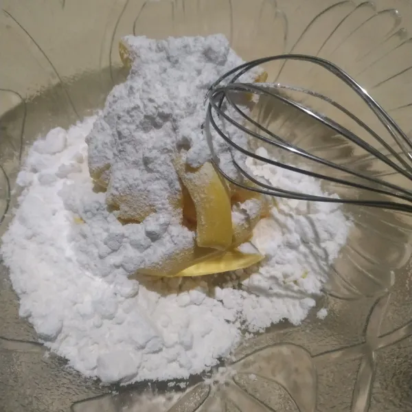 Dalam wadah, campur margarin dan gula halus. Aduk menggunakan whisk hingga tercampur rata.