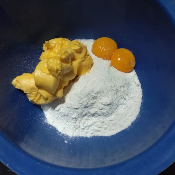 Masukkan margarin, gula halus dan kuning telur lalu aduk hingga rata dan lembut.
