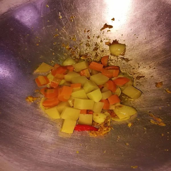 Masukkan kentang dan wortel yang telah direbus setengah matang.