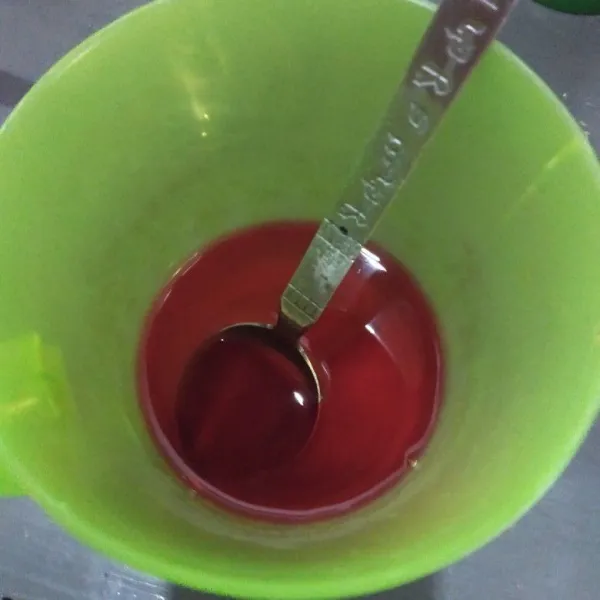 Rebus air dan gula pasir sampai mendidih dan gula larut, tuang ke gelas beri secukupnya pewarna merah, aduk sampai rata.