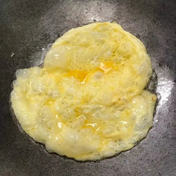 Masukkan telur ke dalam wajan, dan hancurkan.
