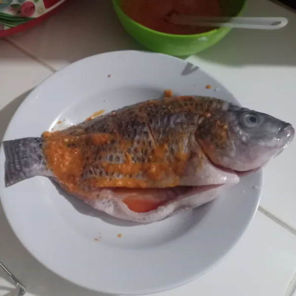 Bersihkan ikan, kucuri jeruk, dan garam, lalu cuci bersih. Kemudian baluri dengan bumbu.