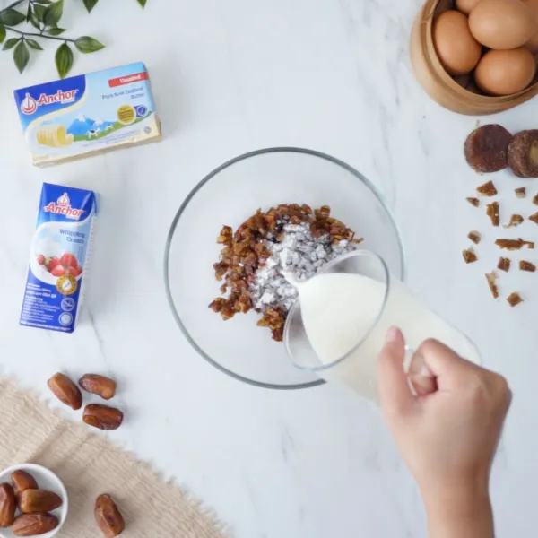 Masukkan kurma yang sudah dicincang dan susu ke dalam wadah. Kemudian hancurkan kurma hingga halus.