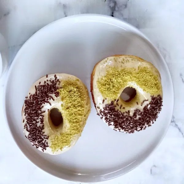 Biarkan donat suhu ruang, kemudian celupkan ke dalam glaze sesuai selera dan beri topping sesuai selera. Lalu sajikan.