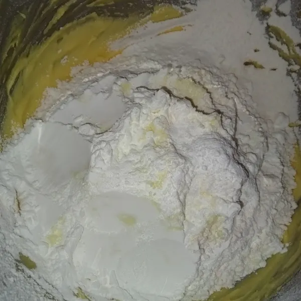 Masukkan tepung terigu, tepung maizena, dan susu bubuk (sambil diayak), lalu aduk rata sampai bisa dibentuk (jika terlalu lembek tambahkan tepung terigu lagi secukupnya).