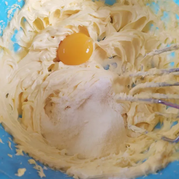 Mixer margarin butter dan gula halus dengan kecepatan sedang, hingga lembut ( kurleb 1 menit ). Masukkan kuning telur dan susu bubuk, mixer asal rata.