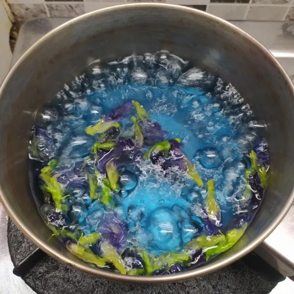 Rebus air dengan bunga telang sampai mendidih dan berubah warna.
Lalu matikan kompor dan saring airnya, buang ampas bunga telang.