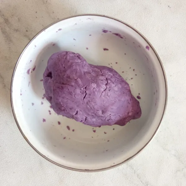 Campur ubi ungu, tepung tapioka, gula pasir dan garam. 
Tuang 3 sdm air sedikit demi sedikit sambil diuleni hingga bisa dibentuk.