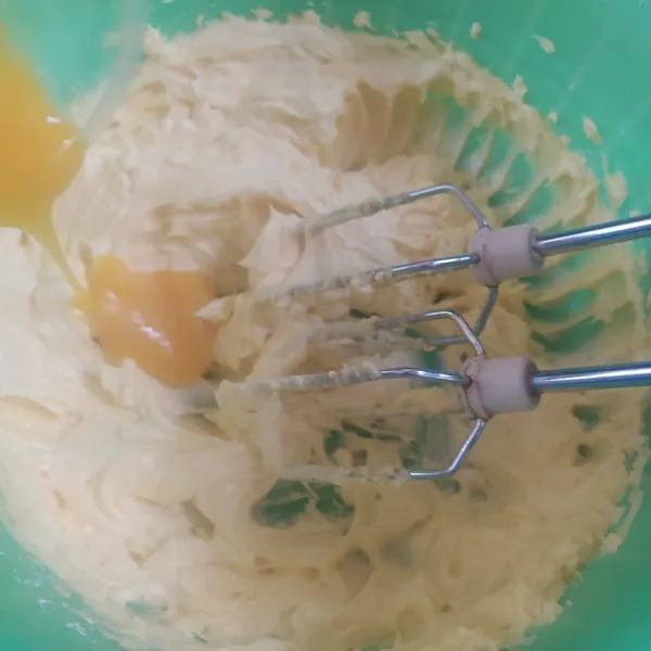 Mixer dengan kecepatan sedang margarin butter dan gula halus, hingga pucat selama 2 menit. Masukkan kuning telur, mixer lagi hingga rata.