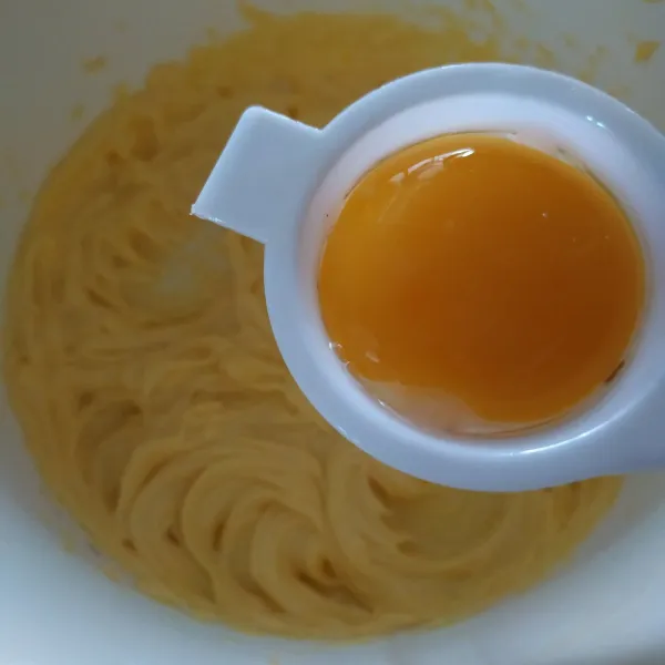 Mixer butter margarine hingga pucat ± 30 detik, tambahkan kuning telur, mixer asal rata.