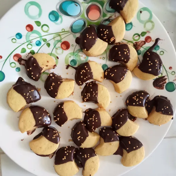 Celupkan kue ke dalam DCC yang sudah dilelehkan dan beri taburan sprinkel di atasnya. Tunggu cokelat dingin dan mengeras.