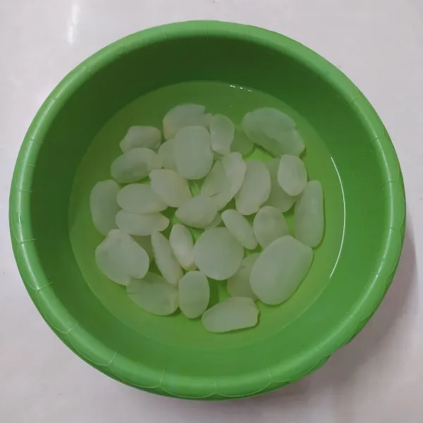 Rendam kolang-kaling dengan air sampai terendam.
Tambahan 1 sdm air kapur sirih, aduk rata.
Rendam selama 30 menit agar bau dan lendir hilang.
