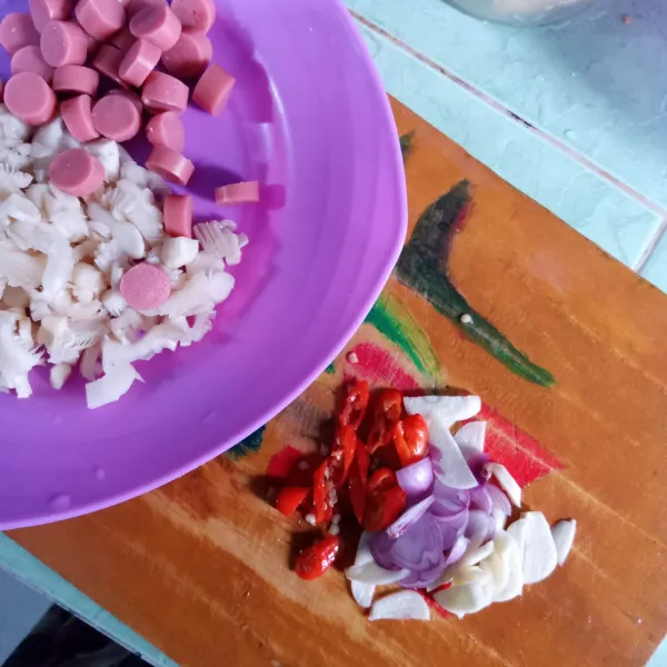 Cacah batang jamur tiram, iris sosis, cabai rawit, bawang merah dan bawang putih.