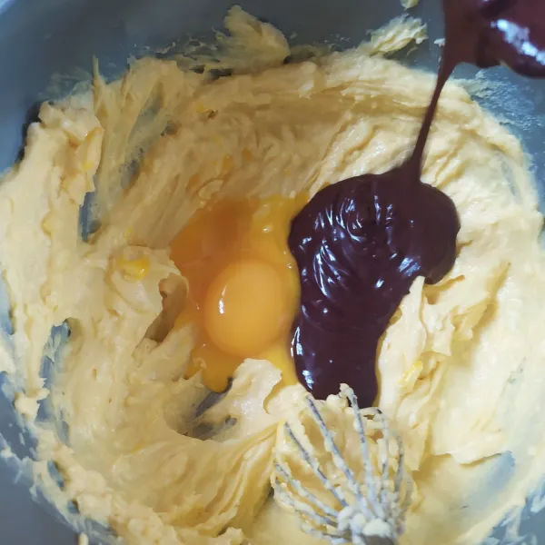 Masukkan kuning telur dan coklat cair (hangat), aduk rata.