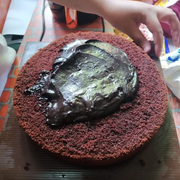 Trimming cake hingga rapi, oles bagian tengah cake dengan ganache.