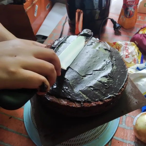 Tumpuk dengan cake lainnya, olesi kembali dengan ganache hingga seluruh permukaan cake tertutupi.