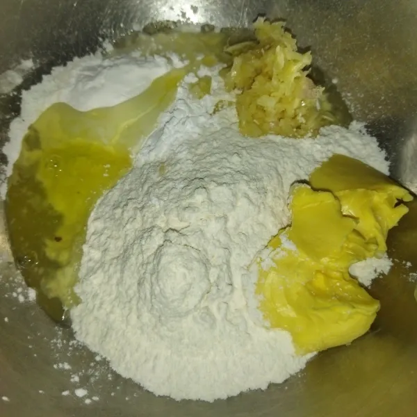 Lalu siapkan wadah, masukkan tepung terigu, tepung sagu, margarin, bawang putih, putih telur, garam dan kaldu bubuk, lalu aduk hingga berbulir.