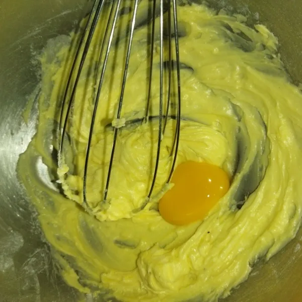 Siapkan wadah, masukkan margarin, gula halus dan vanilli bubuk, aduk hingga lembut, lalu masukkan kuning telur, kocok hingga tercampur rata.