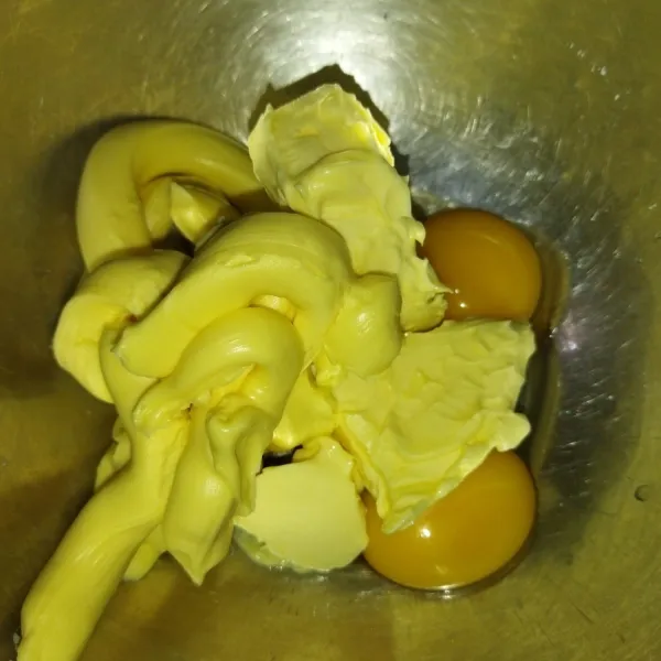Siapkan wadah, masukkan margarin, butter dan kuning telur.