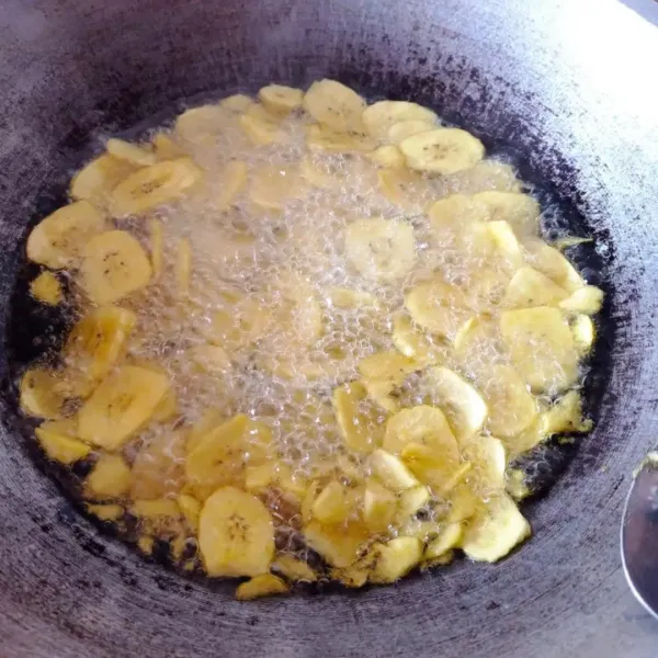Panaskan minyak goreng, masukkan pisang dan goreng dengan api sedang, sesekali di aduk.